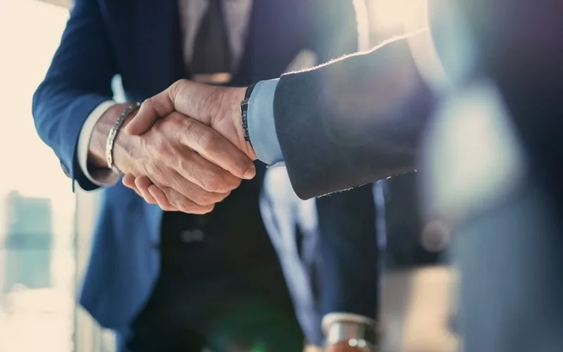 Poignée de main entre deux dirigeants symbolisant le partenariat entre Eterra Partners et Assent