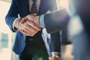 Poignée de main entre deux dirigeants symbolisant le partenariat entre Eterra Partners et Assent